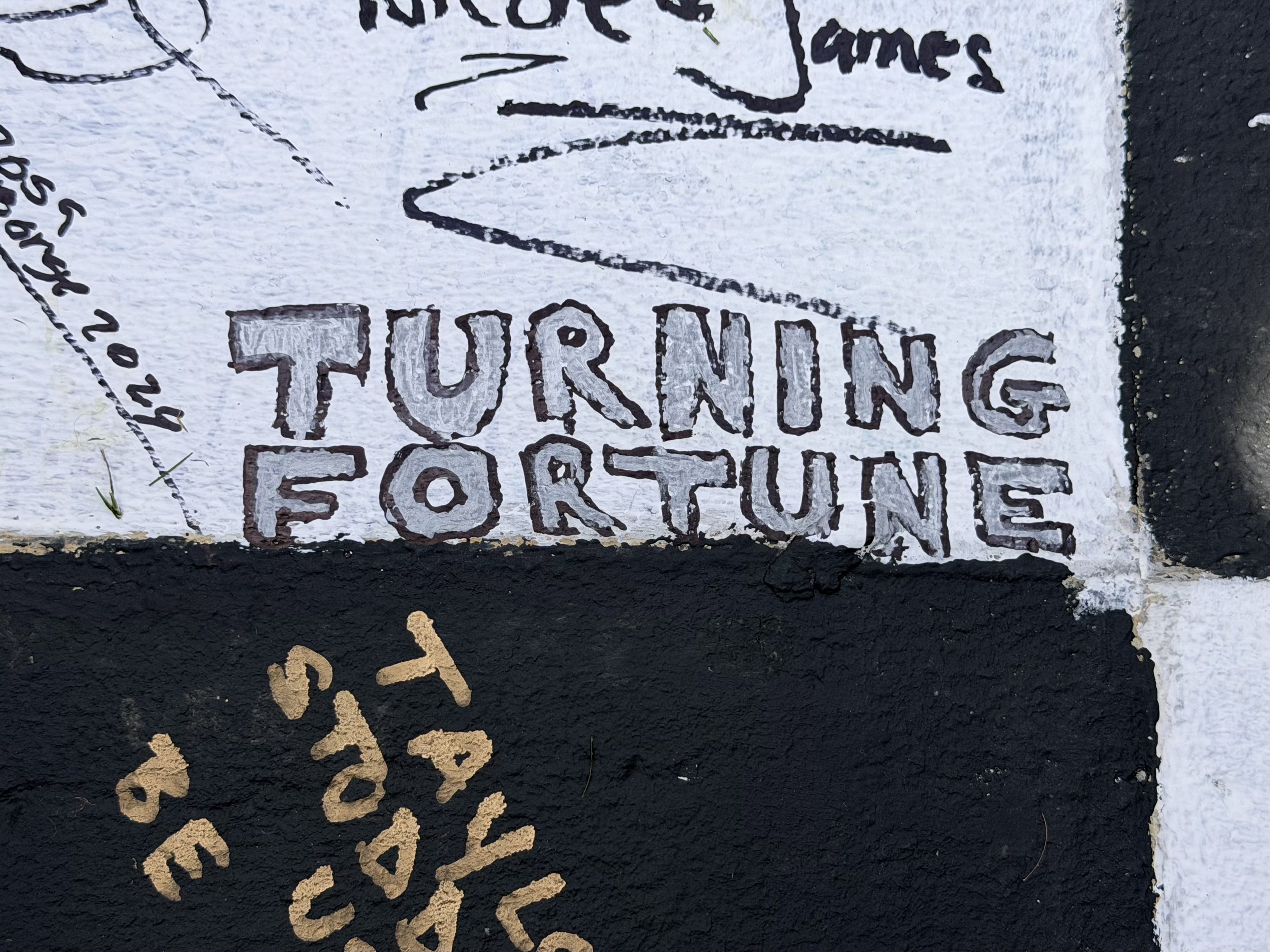 Turning Fortune written in silver bubble letters on the start/finish line at Daytona International Speedway